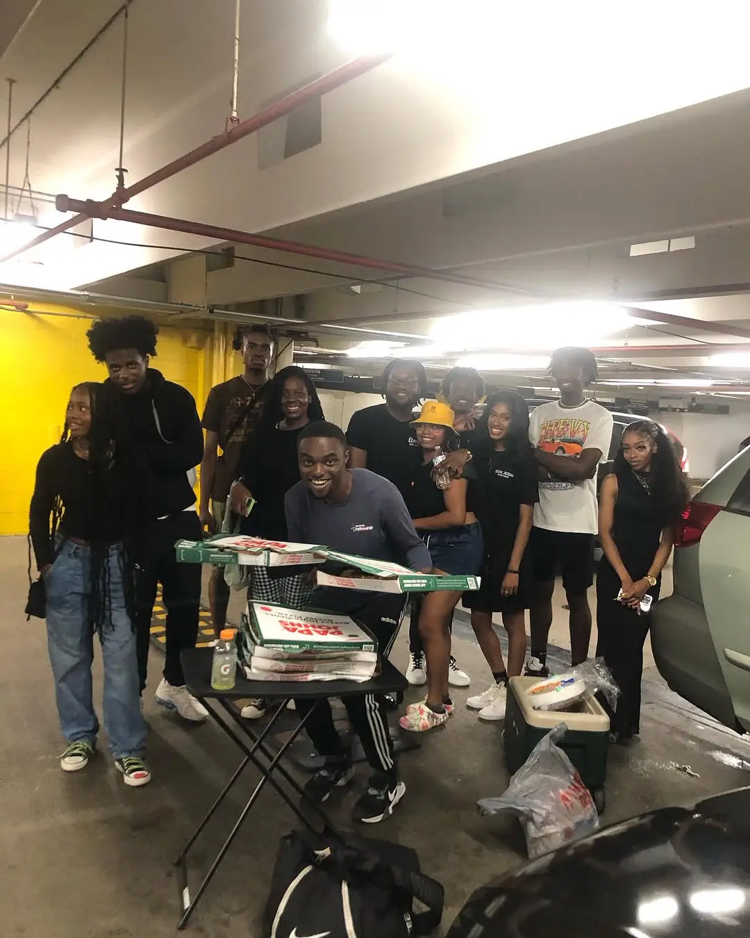 Community gathering with pizza in a parking garage - real life, zero filter
